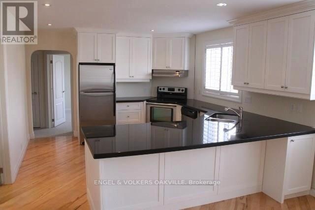 A kitchen with white cabinets and a black countertop.