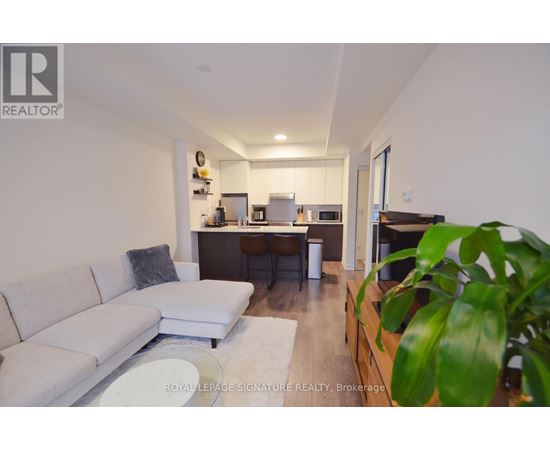 A living room with a white couch and a wooden cabinet.