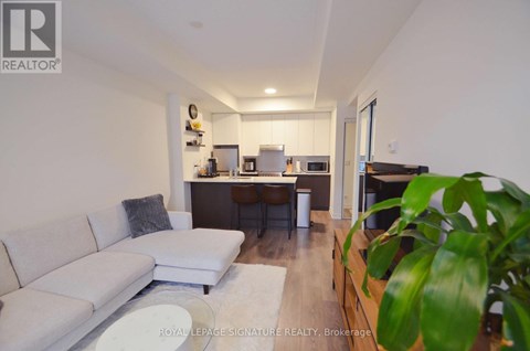 A living room with a white couch and a wooden cabinet.
