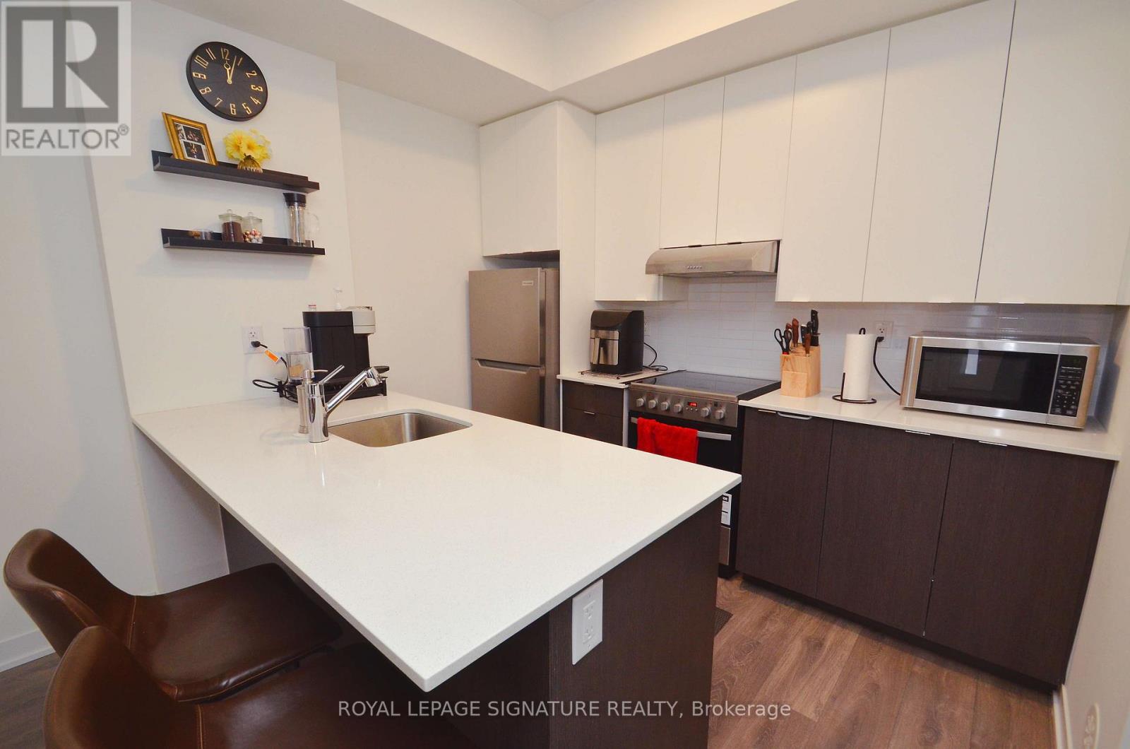A kitchen with a white countertop and brown chairs.