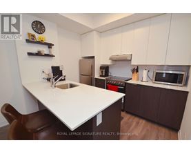 A kitchen with a white countertop and brown chairs.