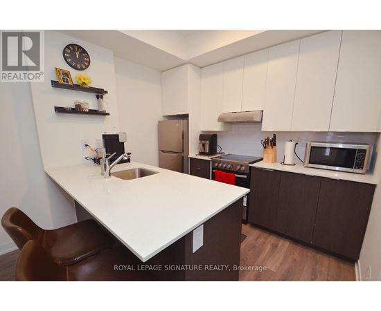 A kitchen with a white countertop and brown chairs.