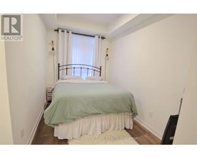 A bedroom with a bed covered in a green and white bedspread.