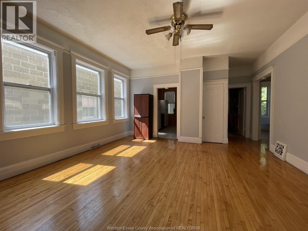 A room with wooden floors and a ceiling fan.
