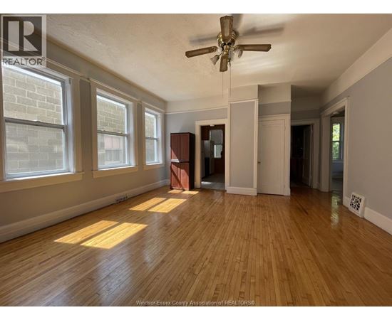 A room with wooden floors and a ceiling fan.