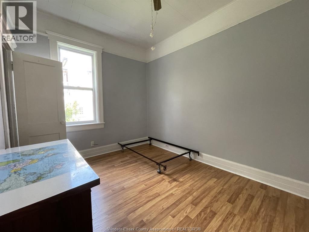 A room with wooden flooring and a large window.