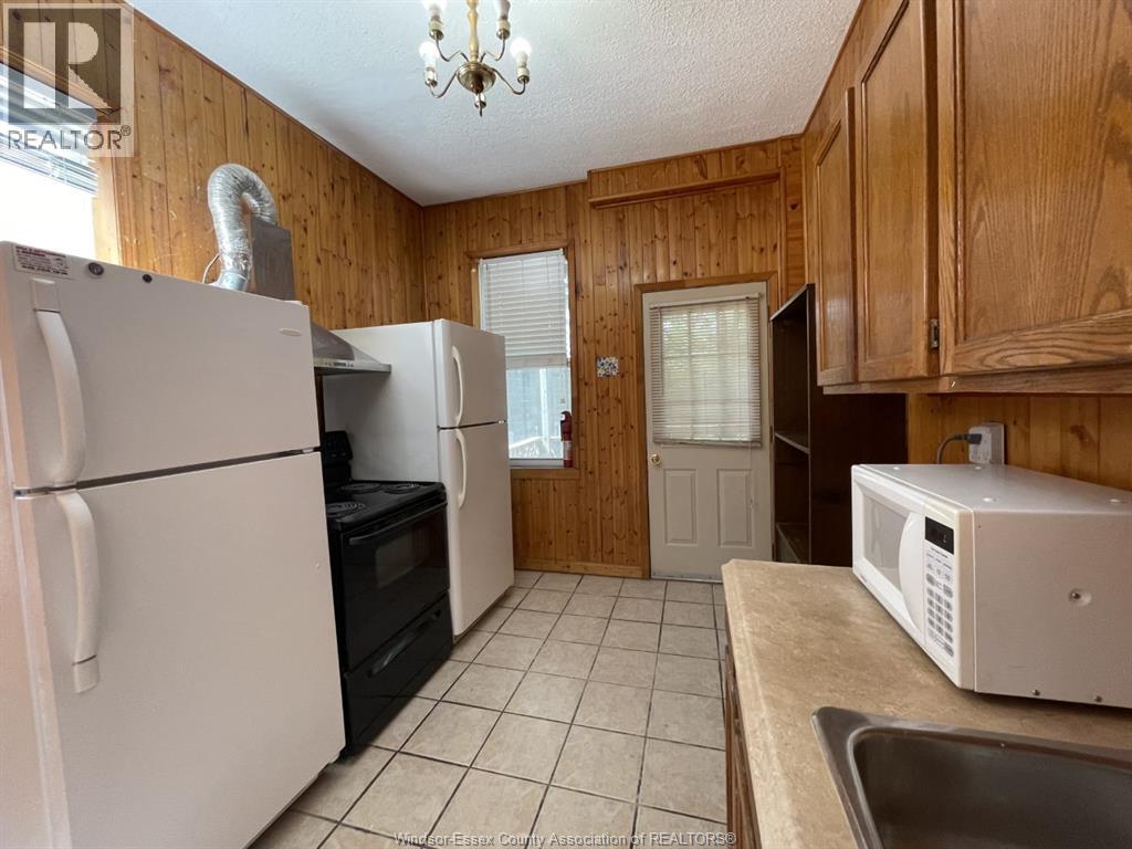 A kitchen with wooden cabinets and a white fridge.