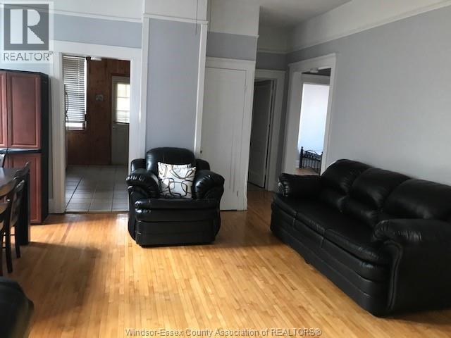 A living room with a black leather couch and chair.