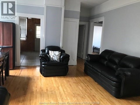A living room with a black leather couch and chair.