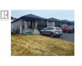 A grey car is parked in front of a house with a sign that says "REALTOR".