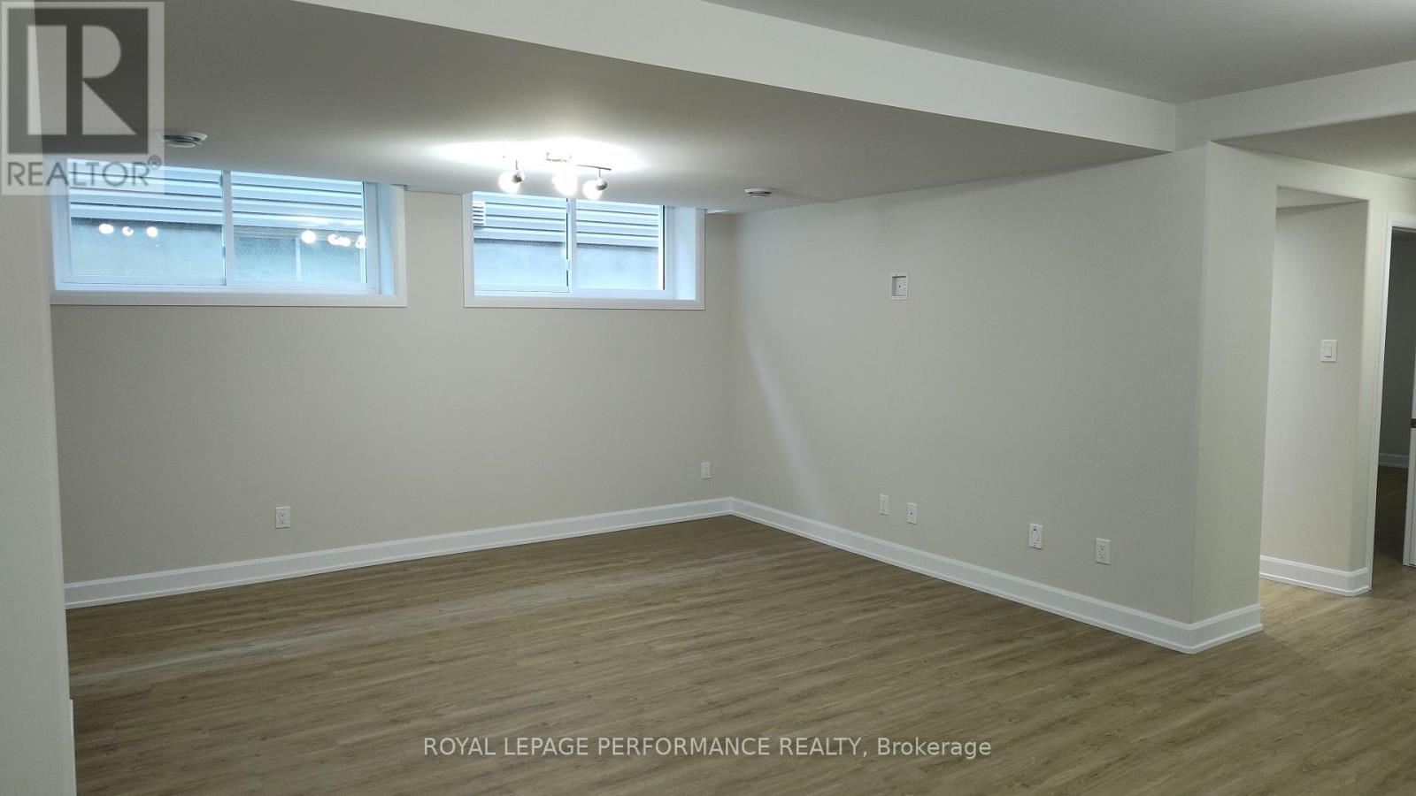 A room with wooden flooring and white walls.