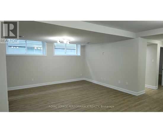 A room with wooden flooring and white walls.