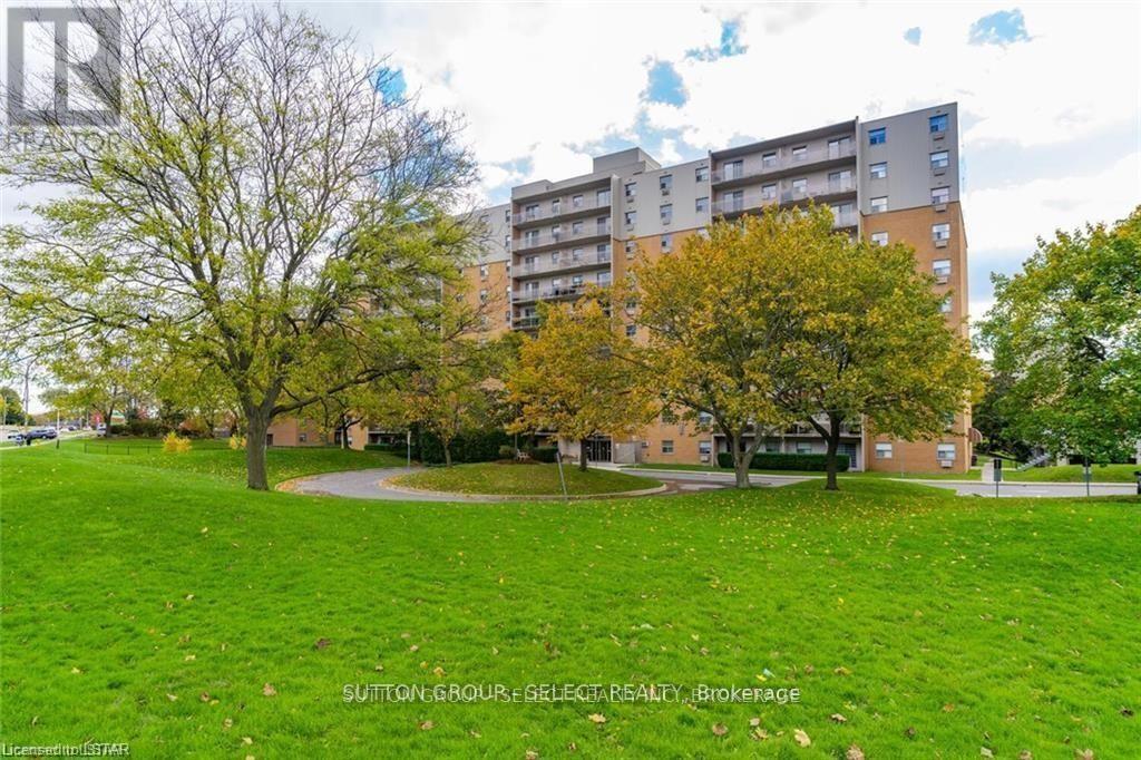 A grassy area in front of a building with trees.