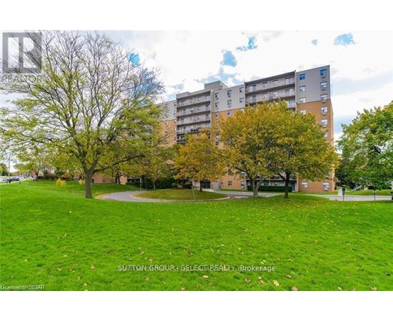 A grassy area in front of a building with trees.