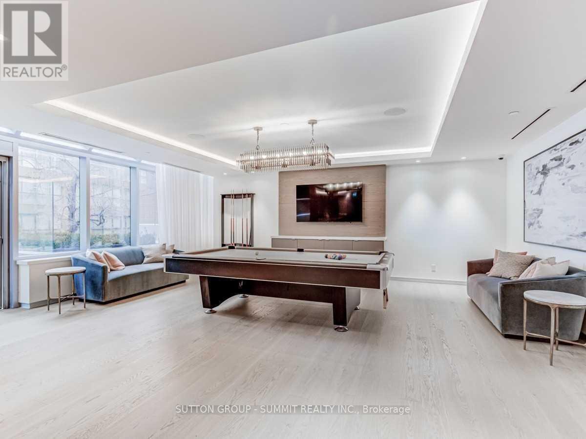 A spacious living room with a pool table and a couch.
