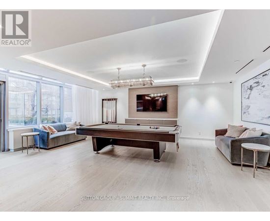 A spacious living room with a pool table and a couch.