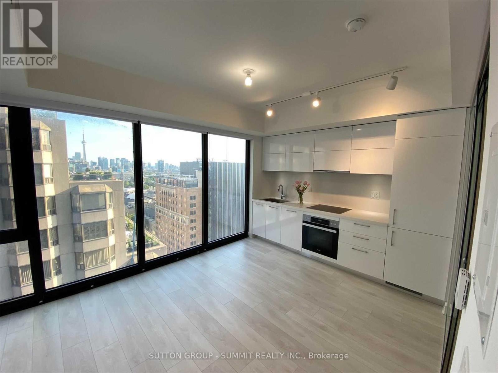 A spacious kitchen with white cabinets and a view of the city.