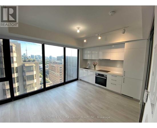A spacious kitchen with white cabinets and a view of the city.