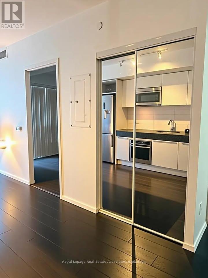 A modern kitchen with white cabinets and black countertops.