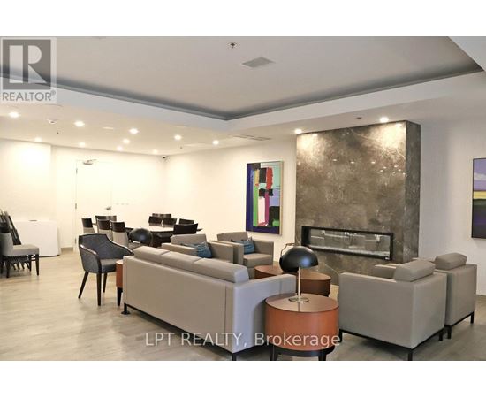 A living room with a grey couch and a fireplace.