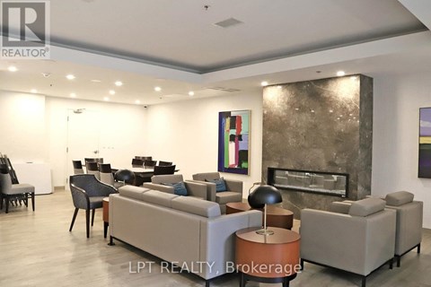 A living room with a grey couch and a fireplace.