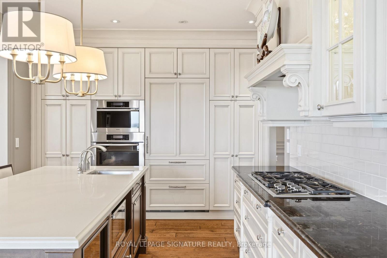 A kitchen with white cabinets and a black stove top.