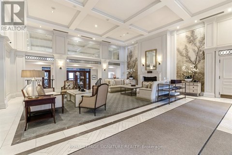 A well-lit, spacious living room with a large rug and a variety of seating options.