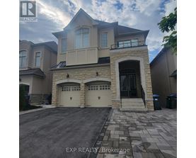 A large house with a stone entrance and two garages is for sale.