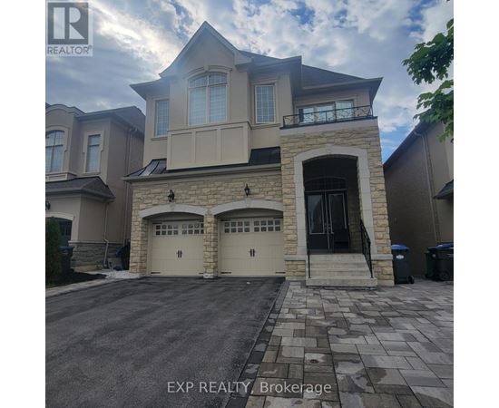A large house with a stone entrance and two garages is for sale.