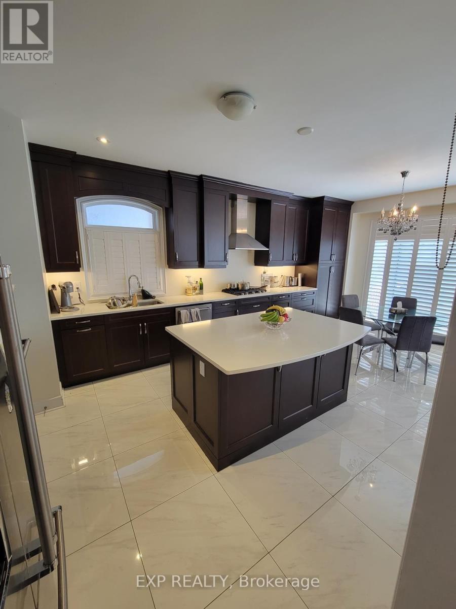 A kitchen with dark brown cabinets and a white island.
