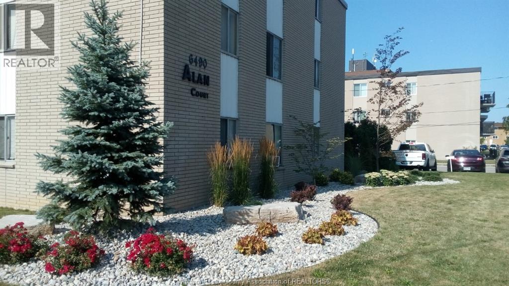 A realtor sign is on the side of a building.