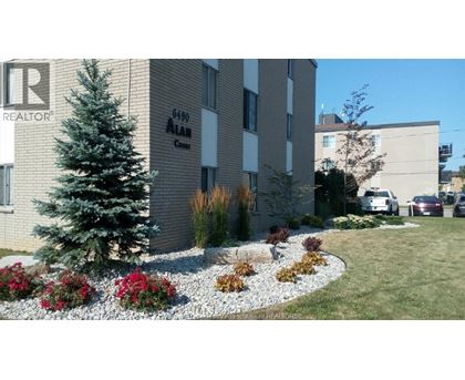 A realtor sign is on the side of a building.