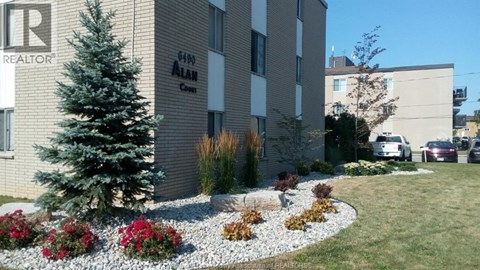 A realtor sign is on the side of a building.