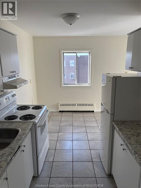 A kitchen with white cabinets and a black stove top.