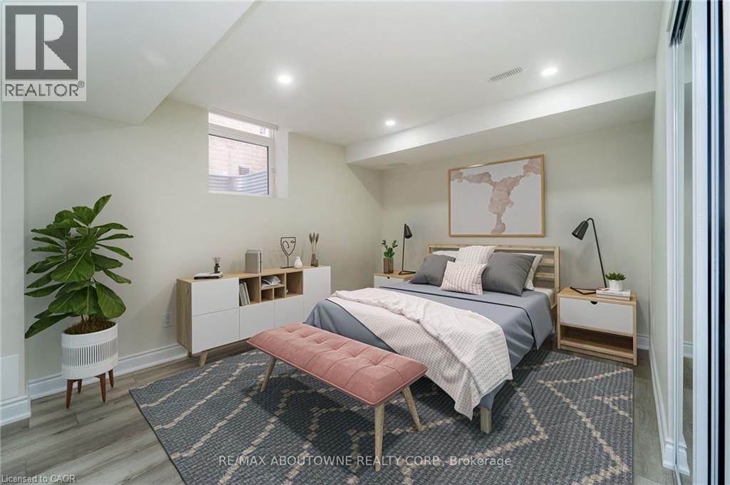 A bedroom with a bed, nightstand, and a plant.