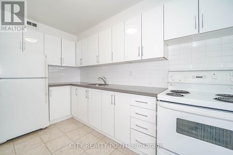 A white kitchen with a stove and sink.
