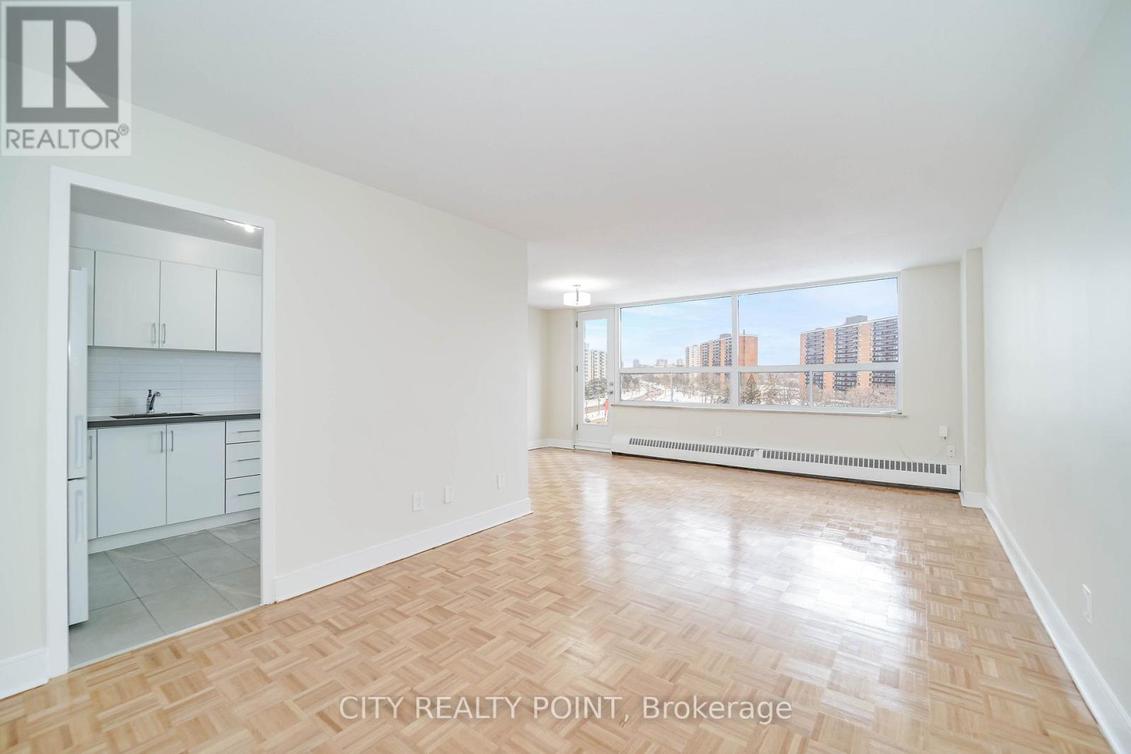 A large empty room with a view of the city.