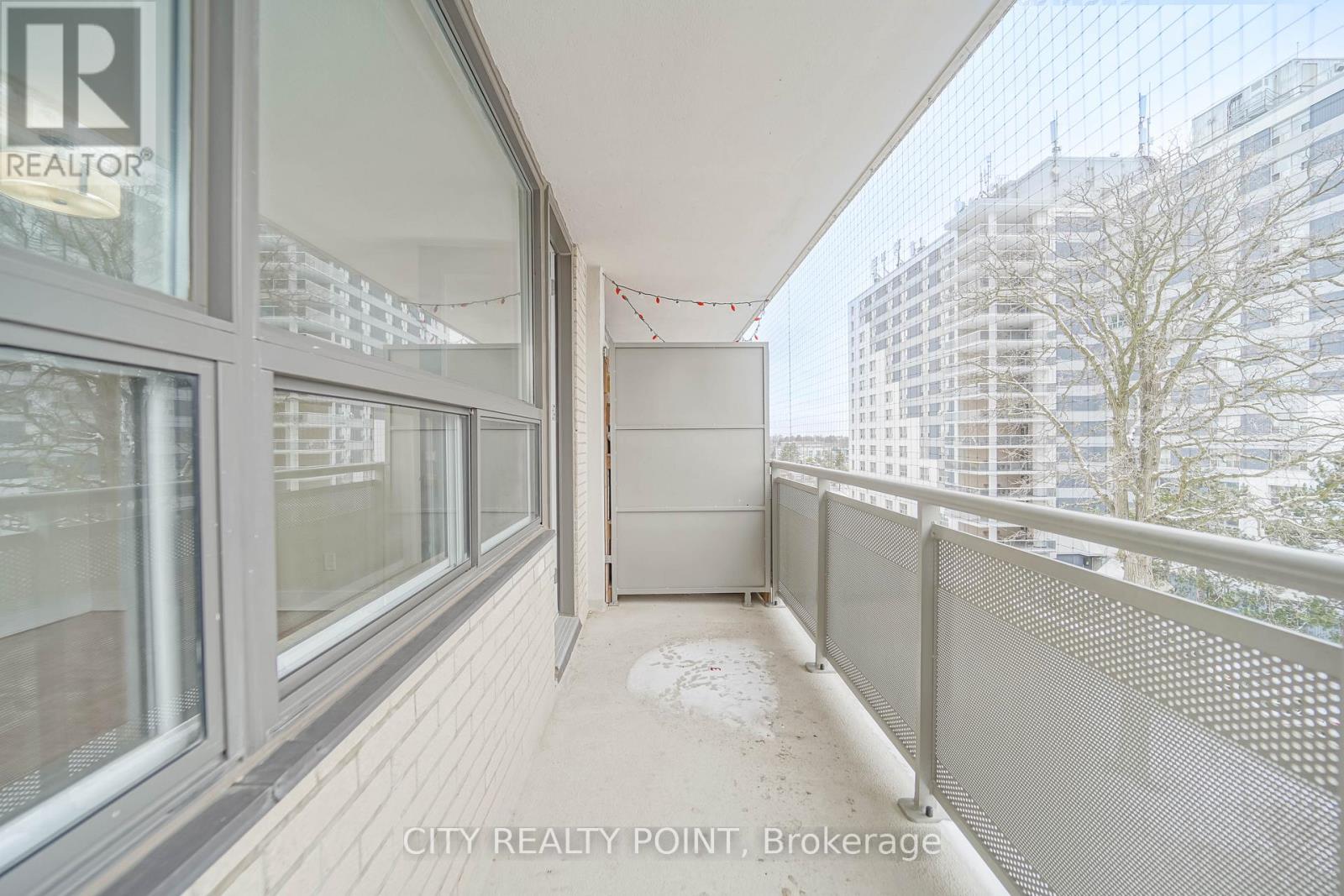 A balcony with a railing and a view of buildings in the distance.