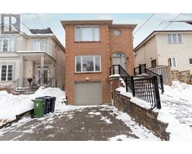 A house with a snow-covered front yard and a sign that says "REALTOR".
