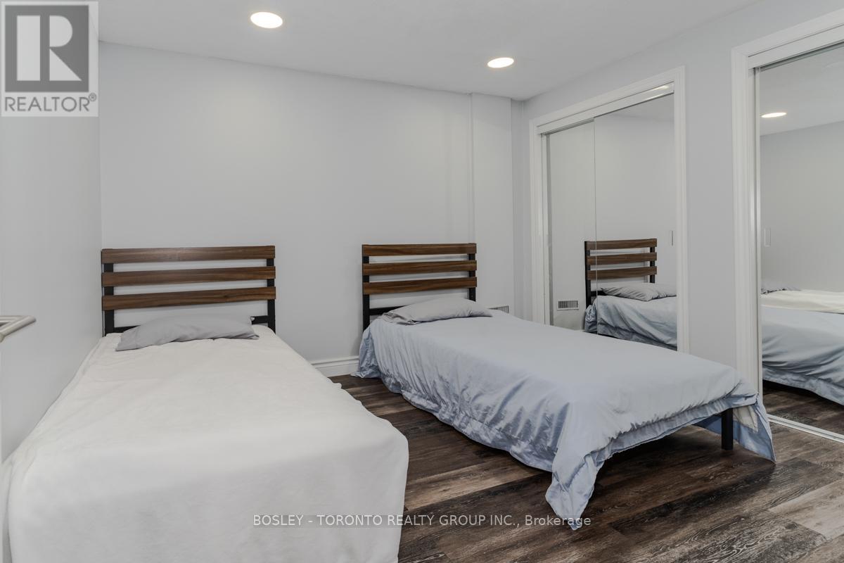A bedroom with two beds and a mirror on the wall.