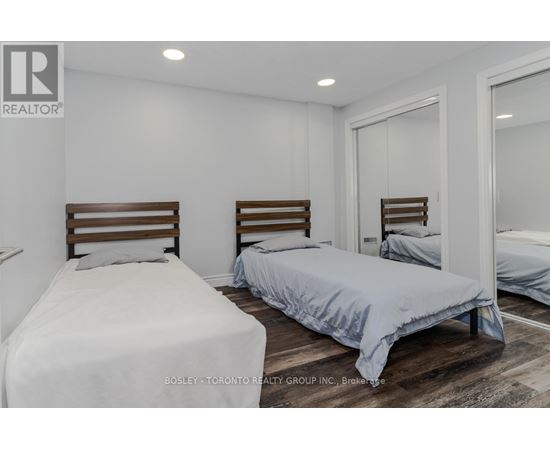 A bedroom with two beds and a mirror on the wall.