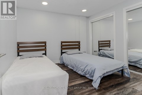 A bedroom with two beds and a mirror on the wall.