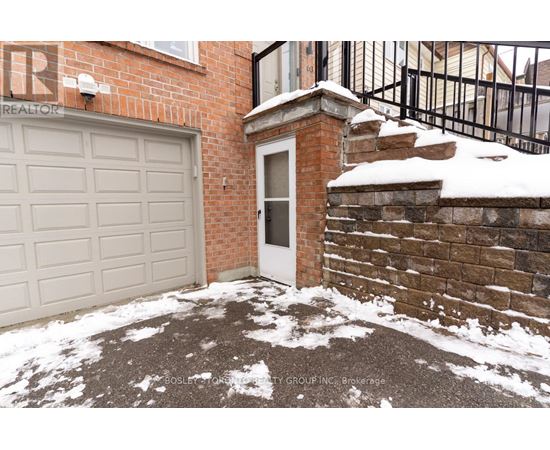 A snow-covered driveway leads to a brick house with a white garage door.