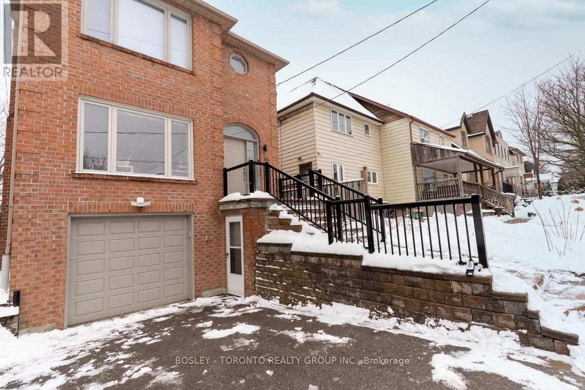 A house with a brick exterior and a garage door is for sale.