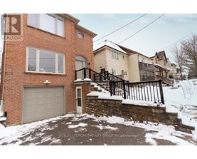 A house with a brick exterior and a garage door is for sale.