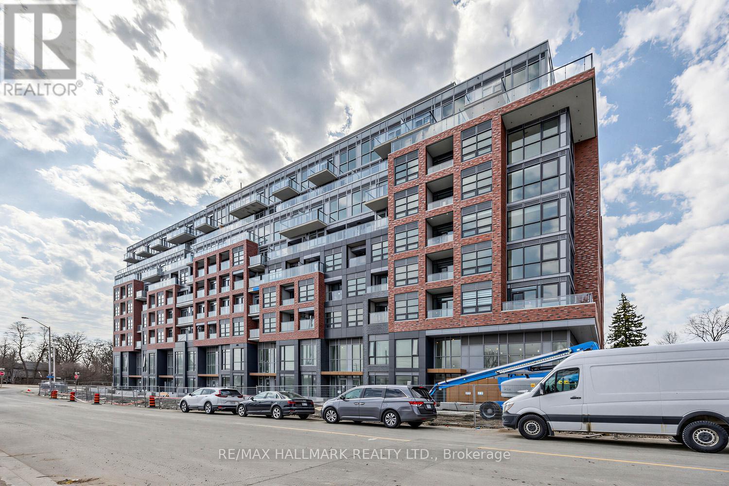 A large multi-story building with a parking lot in front.