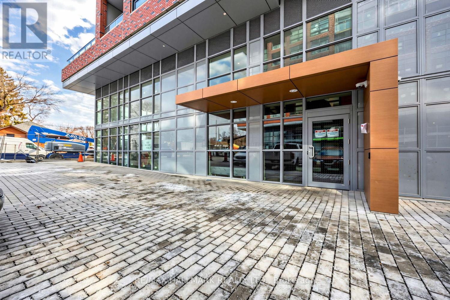 A building with a glass facade and a brick walkway in front.