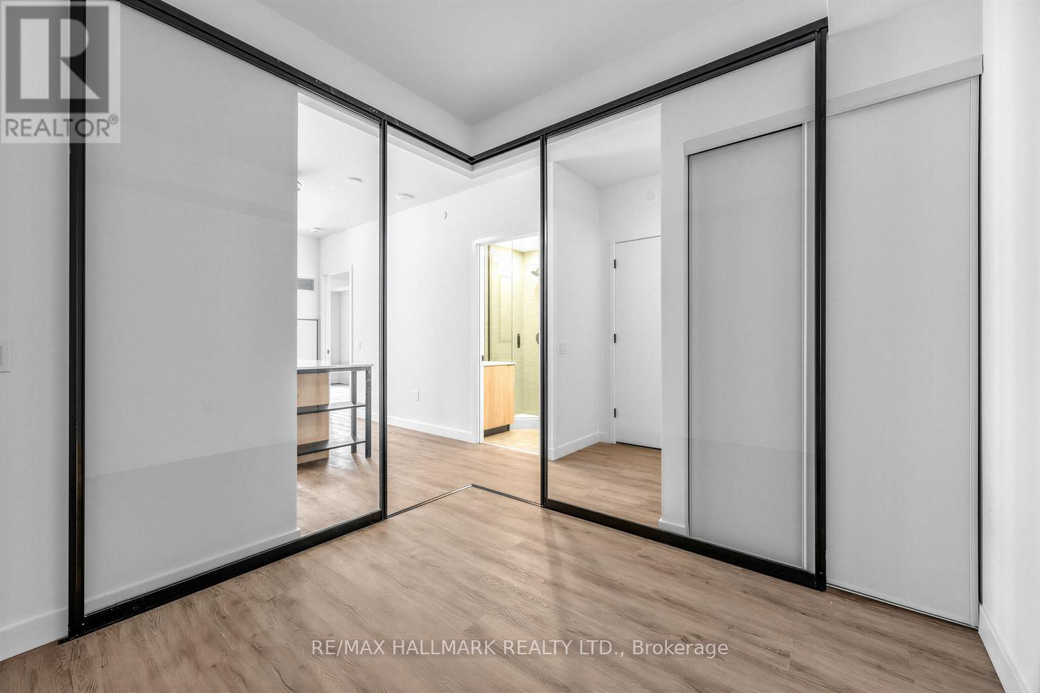 A spacious room with a glass door leading to another room.