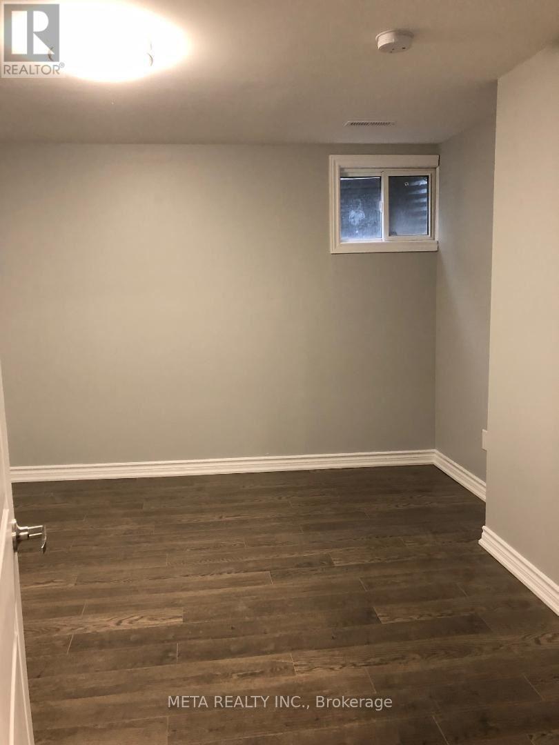 A room with a window and wooden flooring.