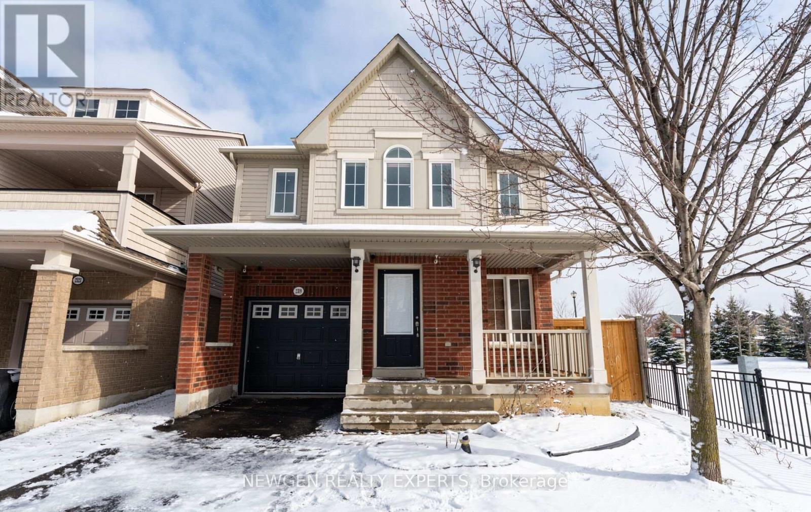 A house with a black front door and a snow-covered ground.
